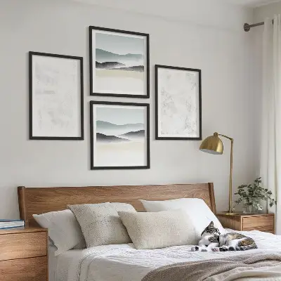 Tavelvägg ovanför soffa med vita fläckar på dukbakgrunden