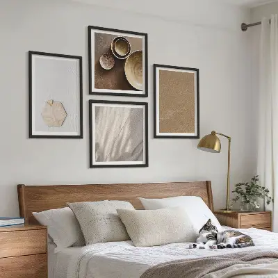 Tavelvägg ovanför soffa i minimalistisk stil med varma texturer
